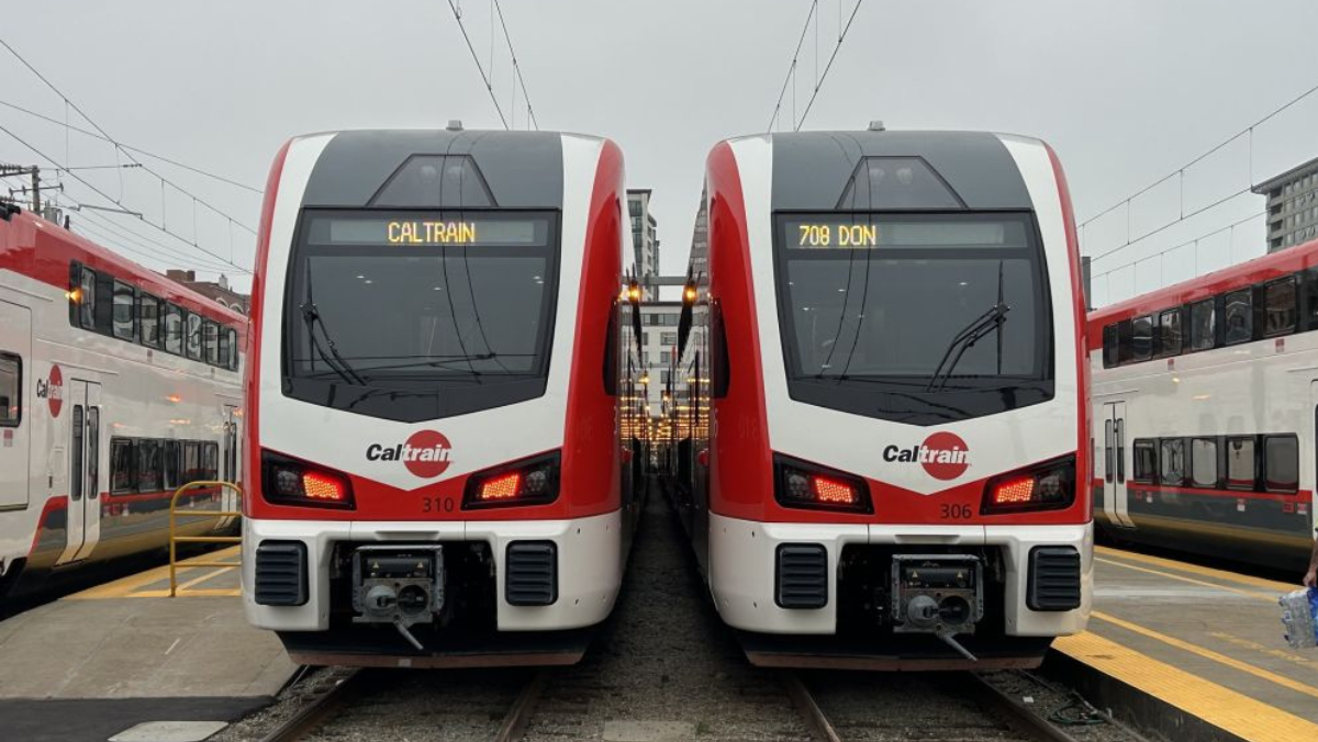 Two Caltrain electric trains side by side on station tracks